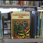 Capa do livro "O Caso da Borboleta Atíria" na biblioteca do bairro. Foto: Juh Oliveira